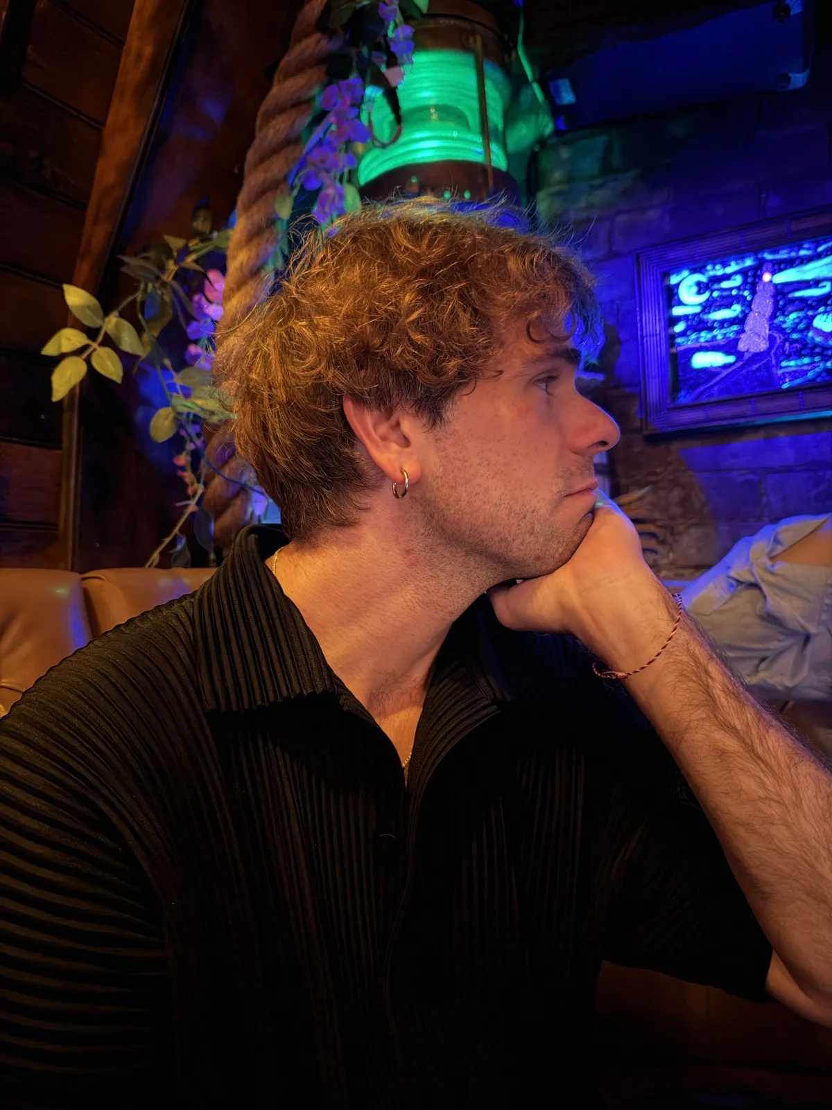 Nick in profile at a neon-lit bar